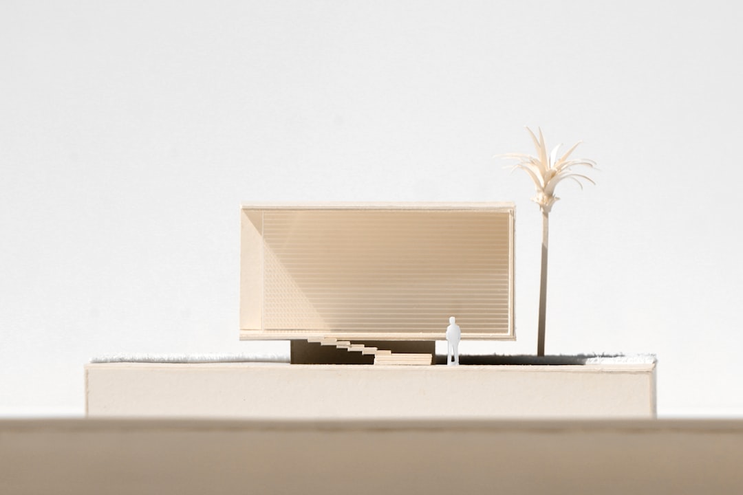 A clean, professional image of a miniature house model resting on one side of a scale, representing the weighing of financial options in real estate.